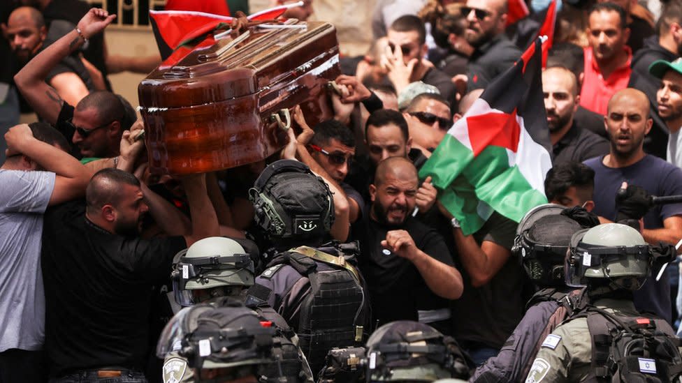 El ataúd cayó y casi termina en el suelo cuando los policías, algunos con porras, se metieron entre una multitud de palestinos reunidos a su alrededor.