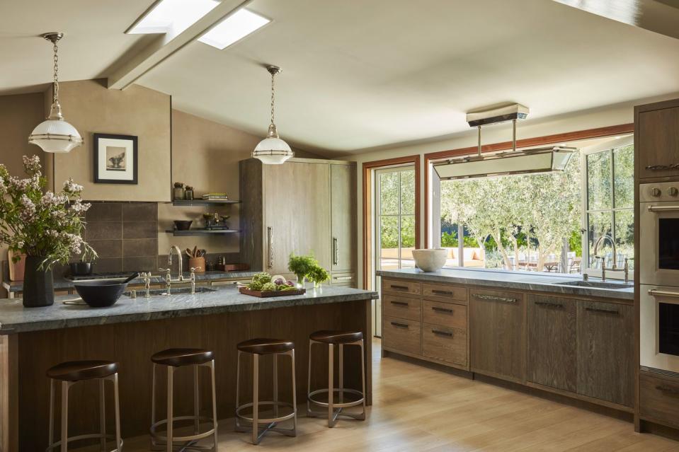 in the kitchen cerused white oak cabinetry brazilian soapstone counters and bronze hardware with a pitch ceiling and giant windows