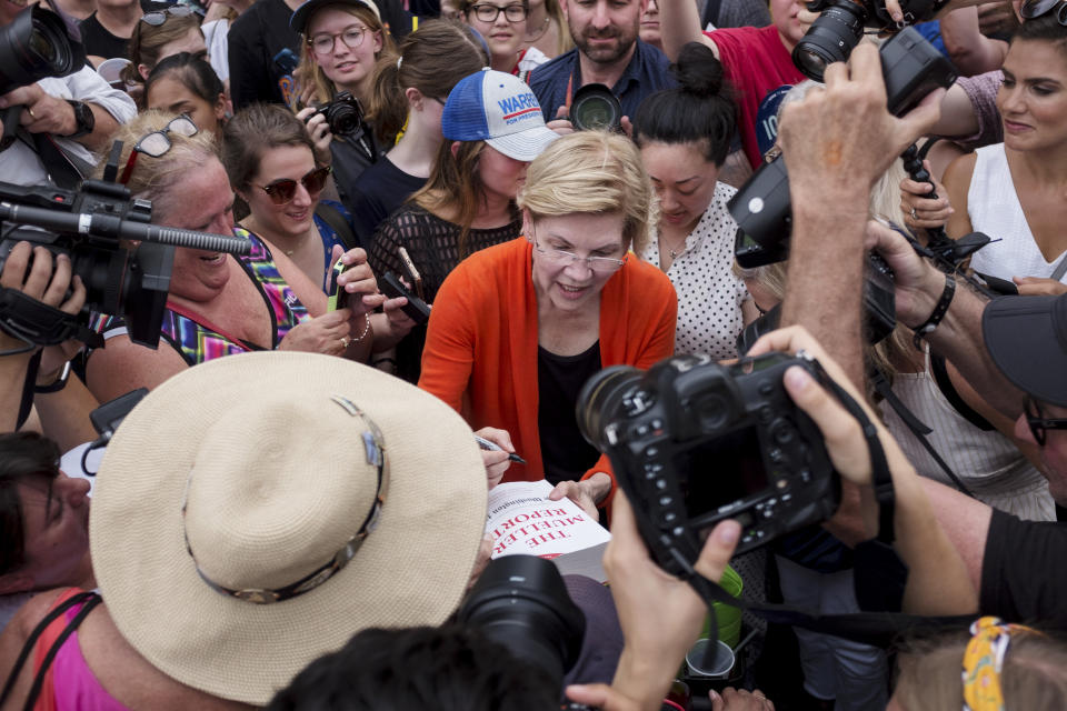 Sen. Elizabeth Warren (D-Mass.) signs a copy of the Mueller report for one of her supporters at the Iowa State Fair on Aug. 10, 2019, in Des Moines, Iowa. (Photo: Seth Herald for HuffPost)