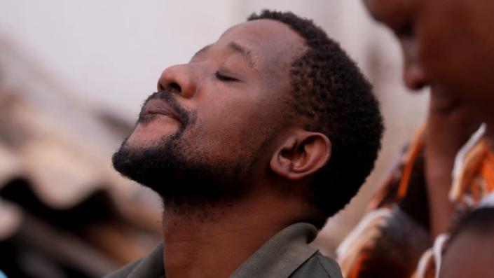 Mmeli Sokhela, who lost three children and a step child when a church collapsed onto his home during flooding, reacts during a visit by South African President Cyril Ramaphosa.