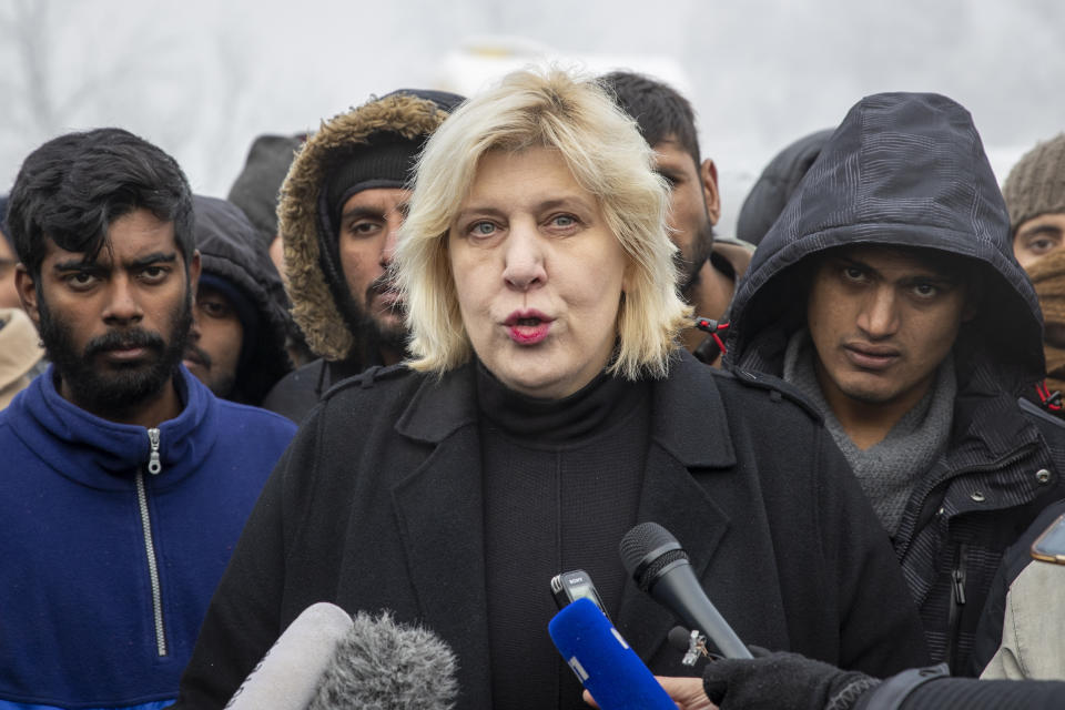 Surrounded by migrants, Dunja Mijatovic, the Council of Europe Commissioner for Human Rights addresses the media at the Vucjak refugee camp outside Bihac, northwestern Bosnia, Tuesday, Dec. 3, 2019. Mijatovic has demanded immediate closure of the migrant camp where hundreds of people have started refusing food and water to protest dismal living conditions as wintry weather sets in. (AP Photo/Darko Bandic)