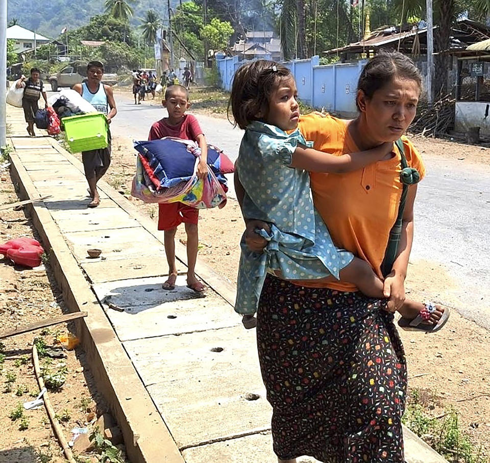 In this photo released by the Free Burma Rangers, families flee after a Buddhist monastery sheltering civilians displaced by fighting in the town of Papun, Karen state, Myanmar was attacked on March 31, 2024 by a regime warplane. (Free Burma Rangers via AP)