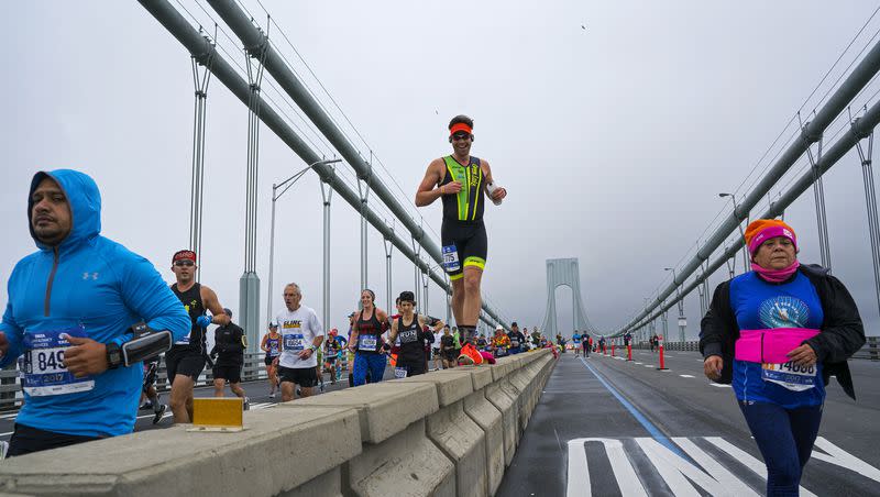 A runner uses the median barrier to make it part of the way across the Verrazano-Narrows Bridge during the New York City Marathon on Sunday, Nov. 5, 2017, in New York. 