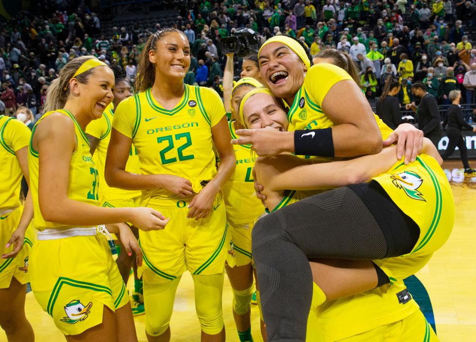 Oregon's Te-Hina Paopao, right, celebrates the win over UConn with teammates after the 72-59 upset Jan. 17, 2022.