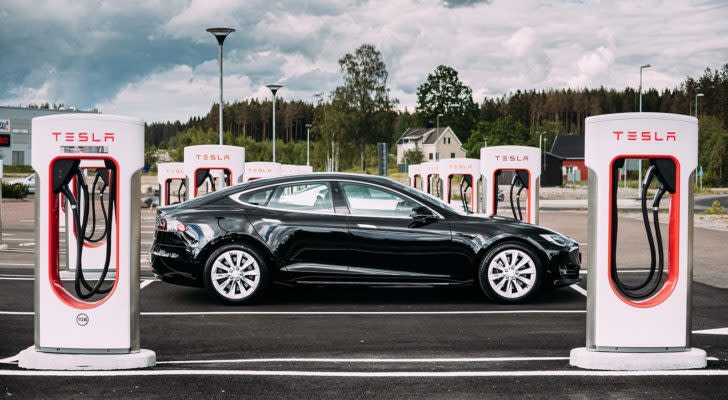 A black Tesla (TSLA) Model S is parked between rows of charging stations.