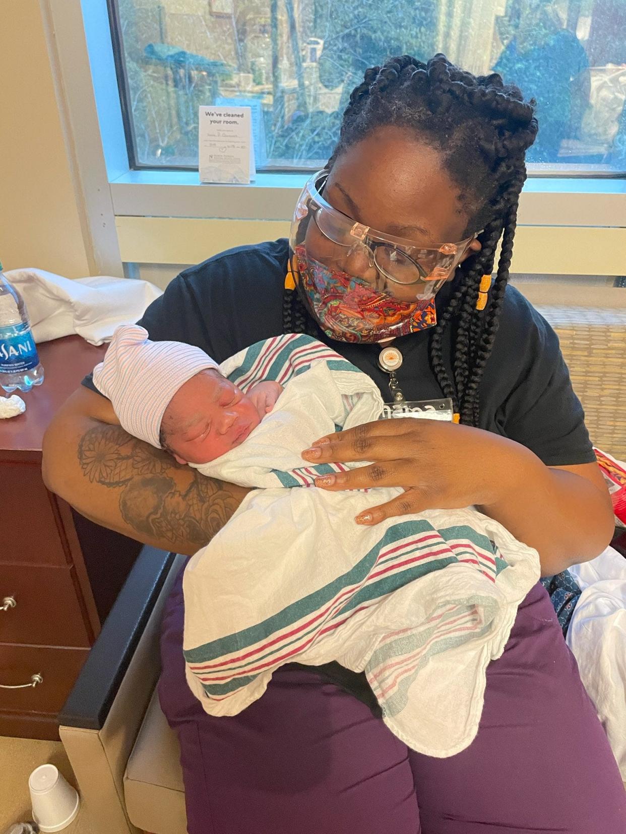 Doula Calvis Jones holds Jaleesa Conyers' newborn baby Jahari after his birth on Aug. 21.