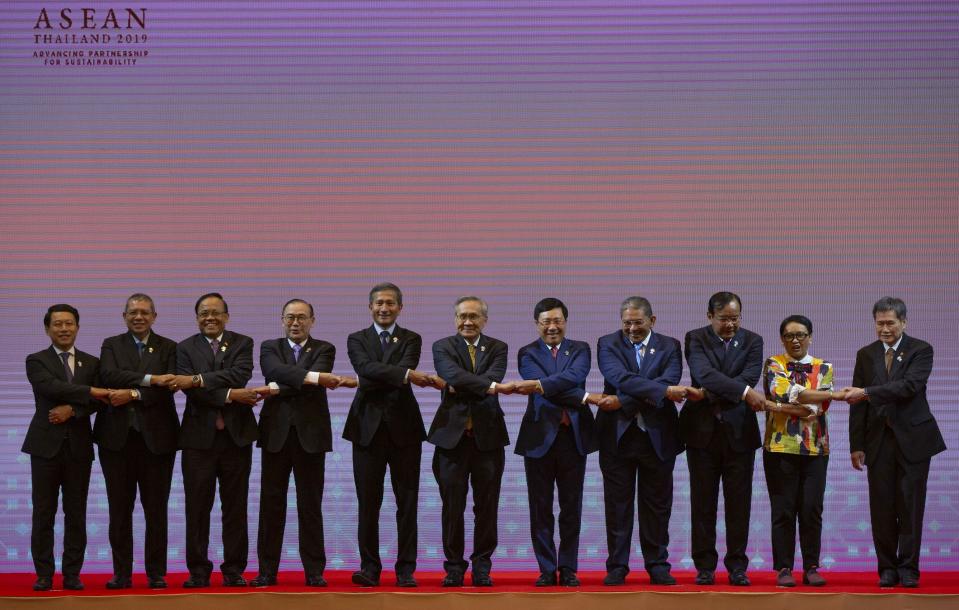 Foreign ministers of the Association of Southeast Asian Nations (ASEAN) from left, Laos Foreign Minister Saleumxay Kommasith, Malaysia Foreign Minister Saifuddin Abdullah, Myanmar Minister of State for Foreign Affaires Kyaw Tin, Philippines Foreign Affaires Secretary Teodoro Locsin Jr., Singapore Foreign Minister Vivian Balakrishnan, Thailand Foreign Minister Don Pramudwinai, Vietnam Foreign Minister Pham Binh Minh, Brunei Second Minister of Foreign affaires and Trade Erywan Yusof, Cambodia Foreign Minister Prak Sokhonn, Indonesia Foreign Minister Retno Marsudi and ASEAN Secretary-General Dato Lim Jock Hoi pose for a group photo during the ASEAN Foreign Ministers' meeting in Bangkok, Thailand, Saturday, June 22, 2019. (AP Photo/Gemunu Amarasinghe)