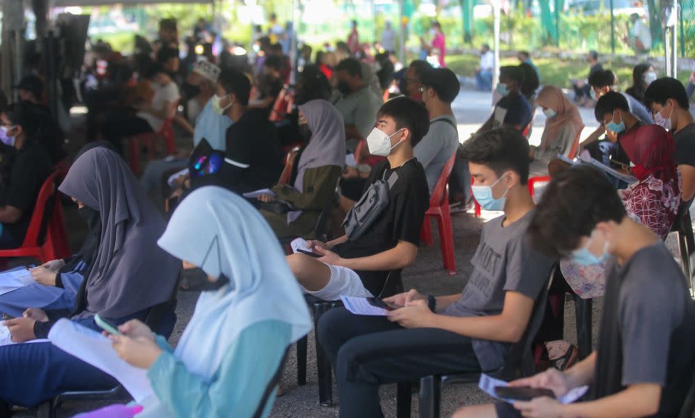 Student wait to receive their Covid-19 jab at the Kinta Town Hall in Batu Gajah September 21, 2021. — Picture by Farhan Najib