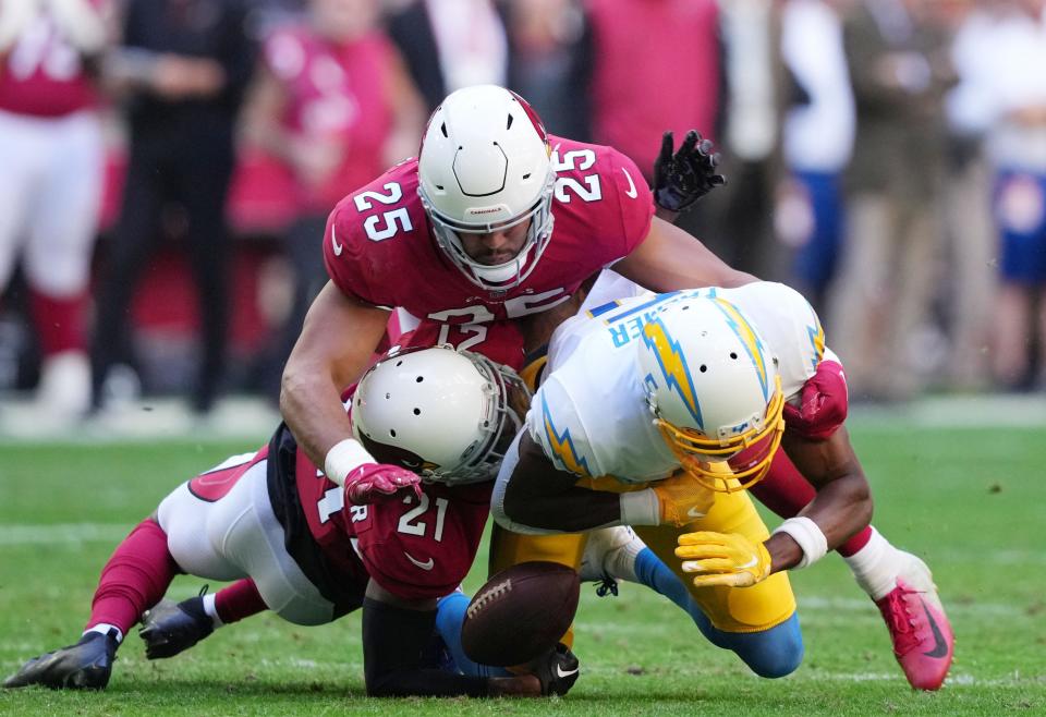 Nov 27, 2022; Glendale, AZ, USA; Los Angeles Chargers wide receiver Joshua Palmer (5) catches a pass and fumbles between Arizona Cardinals linebacker Zaven Collins (25) and cornerback Trayvon Mullen (21) in the first half at State Farm Stadium. Mandatory Credit: Joe Camporeale-USA TODAY Sports