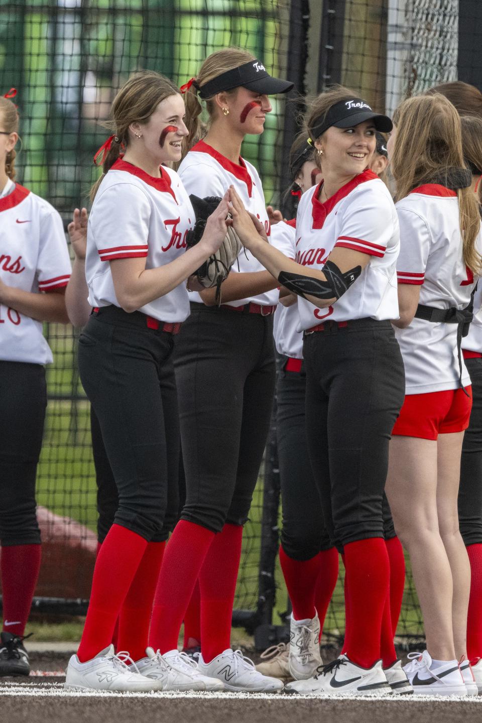 Center Grove High School senior Riley Henson, right, greets teammates onto the field during team introductions before an IHSAA softball game against Pendleton Heights High School, Friday, March 29, 2024. Host Center Grove won, 7-6.