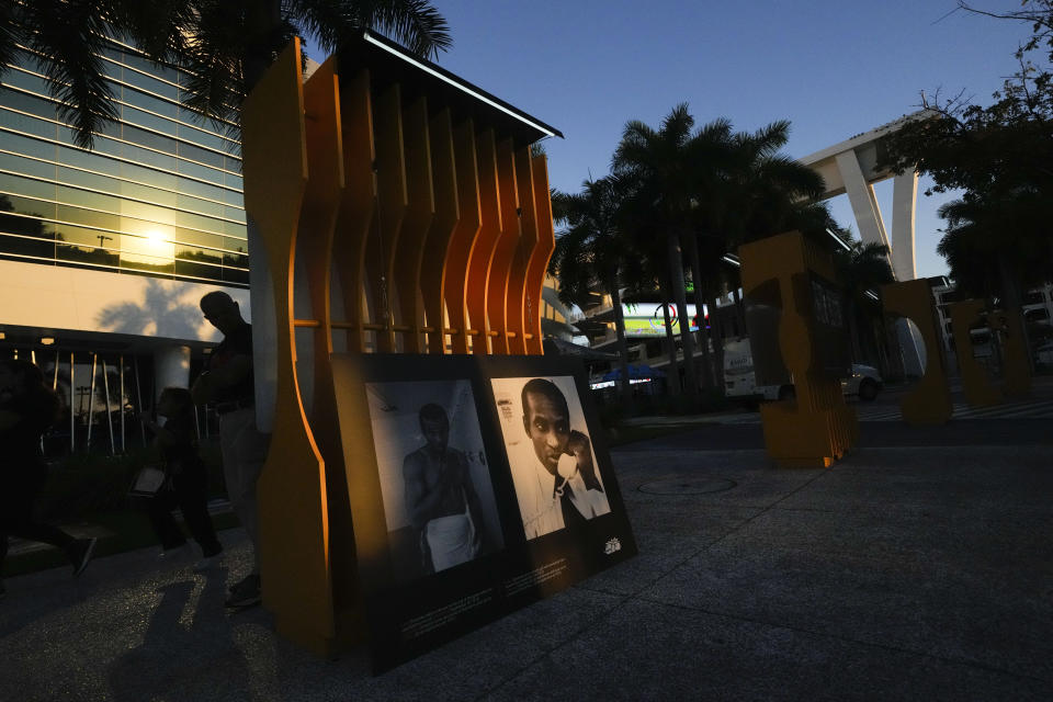 A beam of sunlight illuminates an image of late Major League Baseball player Roberto Clemente, during the installation of a traveling exhibit titled "3000" in a nod to his 3000 career hits, at Miami Marlins' loanDepot Park in Miami, Wednesday, Jan. 31, 2024. The tribute to the Pittsburgh Pirates outfielder will be on display at the park during baseball's Caribbean Series, which runs from Feb. 1 through Feb. 9. (AP Photo/Rebecca Blackwell)