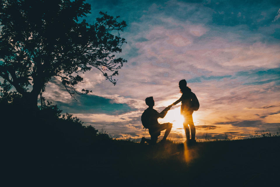 Silhouette Man Proposing Girlfriend Against Sky During Sunset