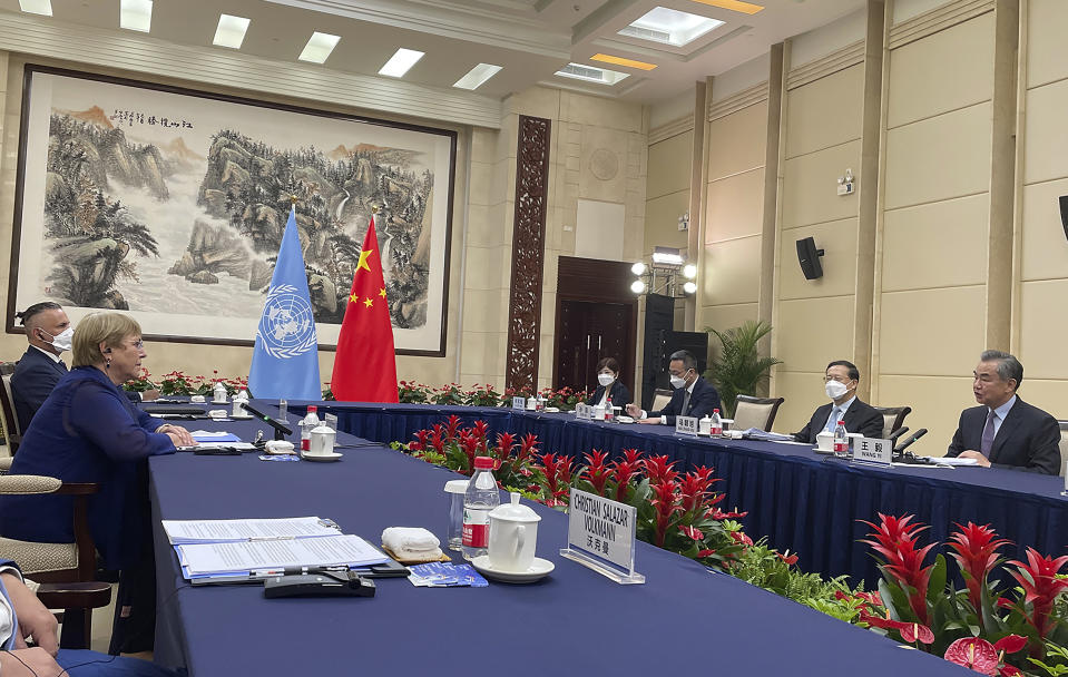 In this photo released by UN Human Rights Office, Chinese Foreign Minister Wang Yi at right meets with the United Nations High Commissioner for Human Rights Michelle Bachelet in Guangzhou, southern China's Guangdong Province on Monday, May 23, 2022. (UN Human Rights Office via AP)