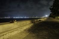 A stray dogs rests at a deserted Marine Drive following restrictions in Mumbai, India, Wednesday April 14, 2021. The teeming metropolis of Mumbai and other parts of Maharashtra, the Indian state worst hit by the pandemic, face stricter restrictions for 15 days starting Wednesday in an effort to stem the surge of coronavirus infections. (AP Photo/Rajanish Kakade)