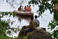 KAZIRANGA, INDIA - JULY 18, 2020: Forest official try to chase a rhino who rests near NH 37 after straying out from flood-affected Kaziranga National Park, in Nagaon district of Assam ,India - PHOTOGRAPH BY Anuwar Ali Hazarika / Barcroft Studios / Future Publishing (Photo credit should read Anuwar Ali Hazarika/Barcroft Media via Getty Images)