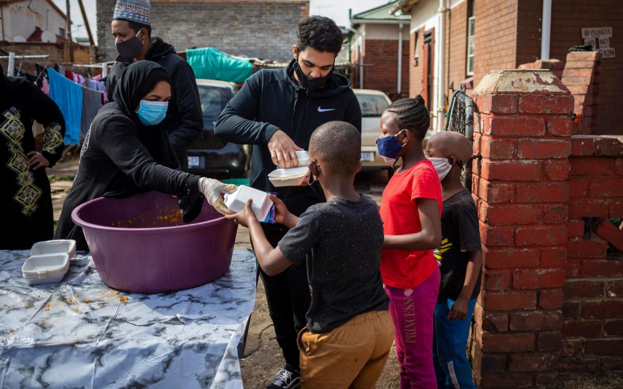 Children collect food parcels in Johannesburg - Kim Ludbrook/Shutterstock