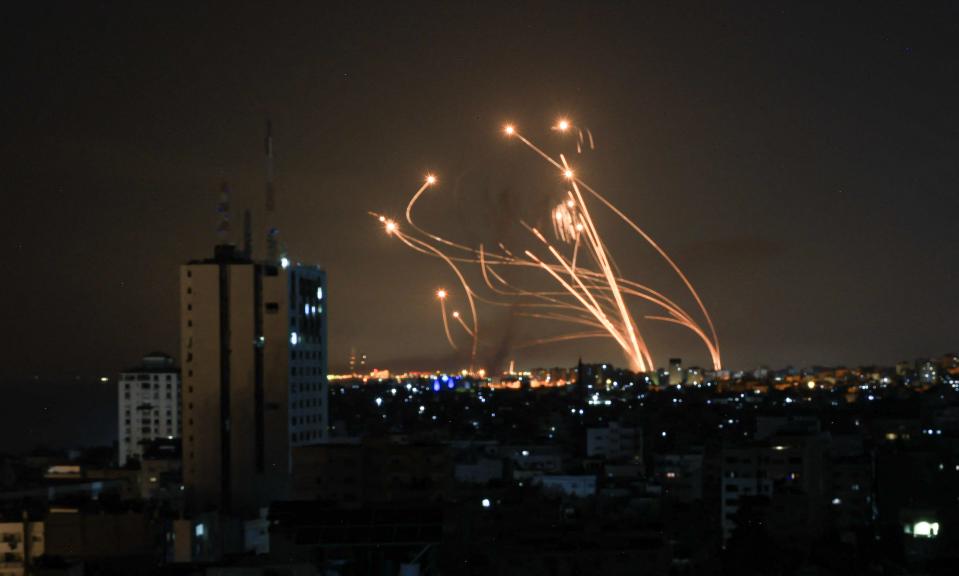 A photo of rockets intercepting each other in the night sky.