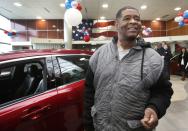 Detroit resident James Robertson reacts next to the 2015 red Ford Taurus sedan he was surprised with as a free gift at the Suburban Ford dealership in Sterling Heights, Michigan, February 6, 2015. The 56-year-old factory worker, known for walking 21 miles to get to and from work for 9 years, is also the recipient of about $300,000 in donations raised by a college student after his story was widely publicized in local media. REUTERS/Rebecca Cook (UNITED STATES - Tags: TRANSPORT SOCIETY)