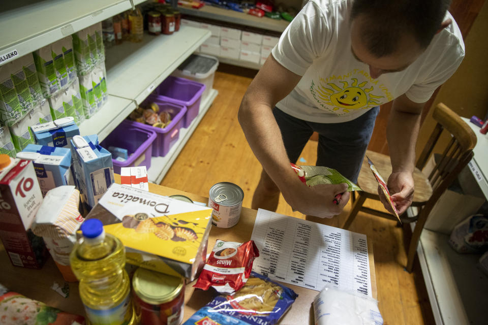 Igor Loparic prepares packages of aid for people in need for help in Pula, Croatia, Tuesday, May 26, 2020. The "Our Dream Their Smile" group has helped people in the tourism-dependent area in the Adriatic survive as the outbreak closed down borders, shutting down hotels, restaurants and other businesses that normally thrive in virus-free times. (AP Photo/Darko Bandic)