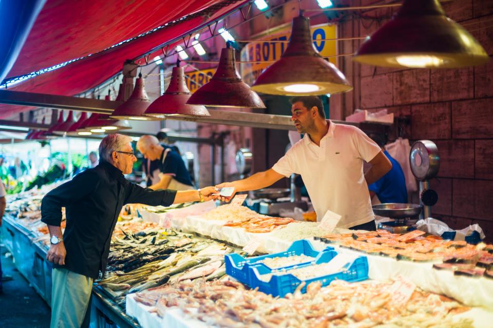 Buying fresh seafood at the Mercato di Ortigia in Siracusa.