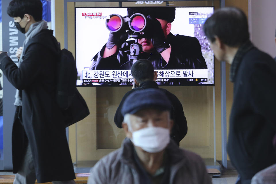 People pass by a TV screen showing a file image of North Korean leader Kim Jong Un during a news program at the Seoul Railway Station in Seoul, South Korea, Sunday, March 29, 2020. North Korea on Sunday fired two suspected ballistic missiles into the sea, South Korea said, calling it "very inappropriate" at a time when the world is battling the coronavirus pandemic. The Korean letters read: " North Korea launched two suspected ballistic missiles into the sea." (AP Photo/Ahn Young-joon)