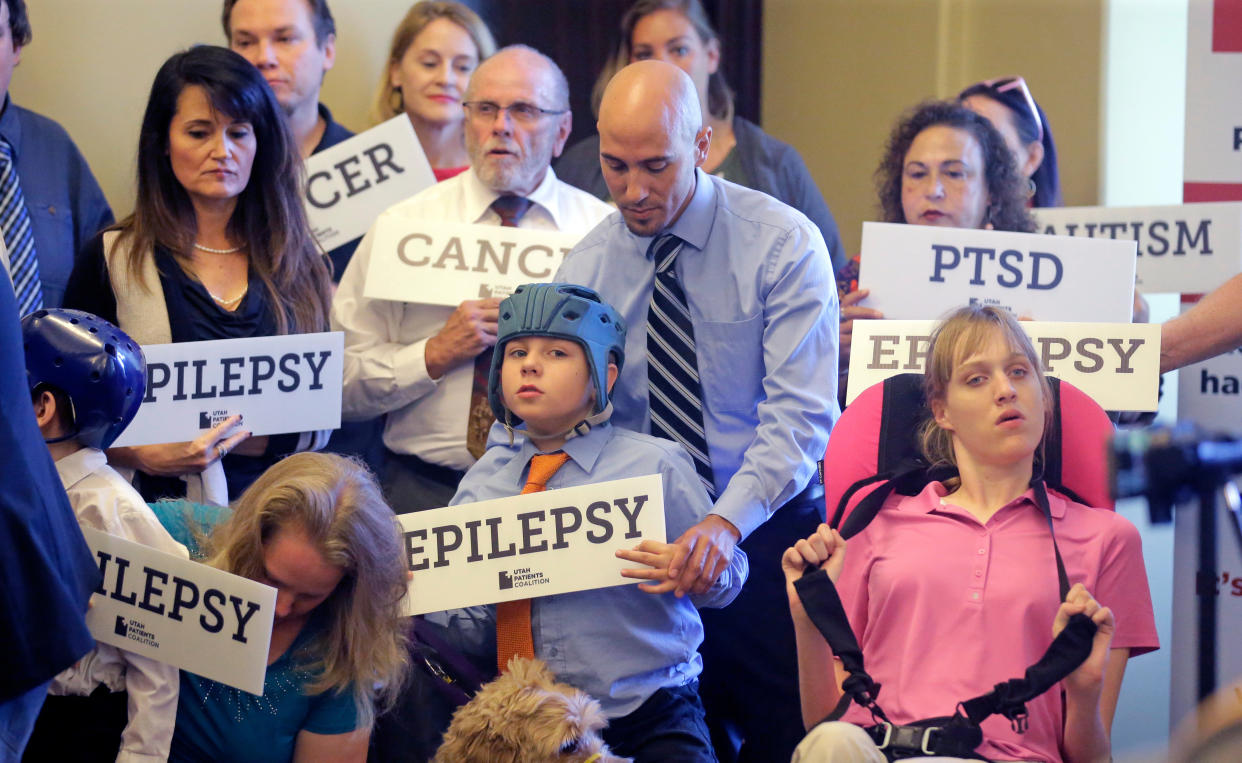 Davis Cromar holds his son Holden, 10, who suffers from epilepsy, while standing with other patients, caregivers and supporters during a Utah Patients Coalition news conference in 2017. (Photo: Rick Bowmer/AP)