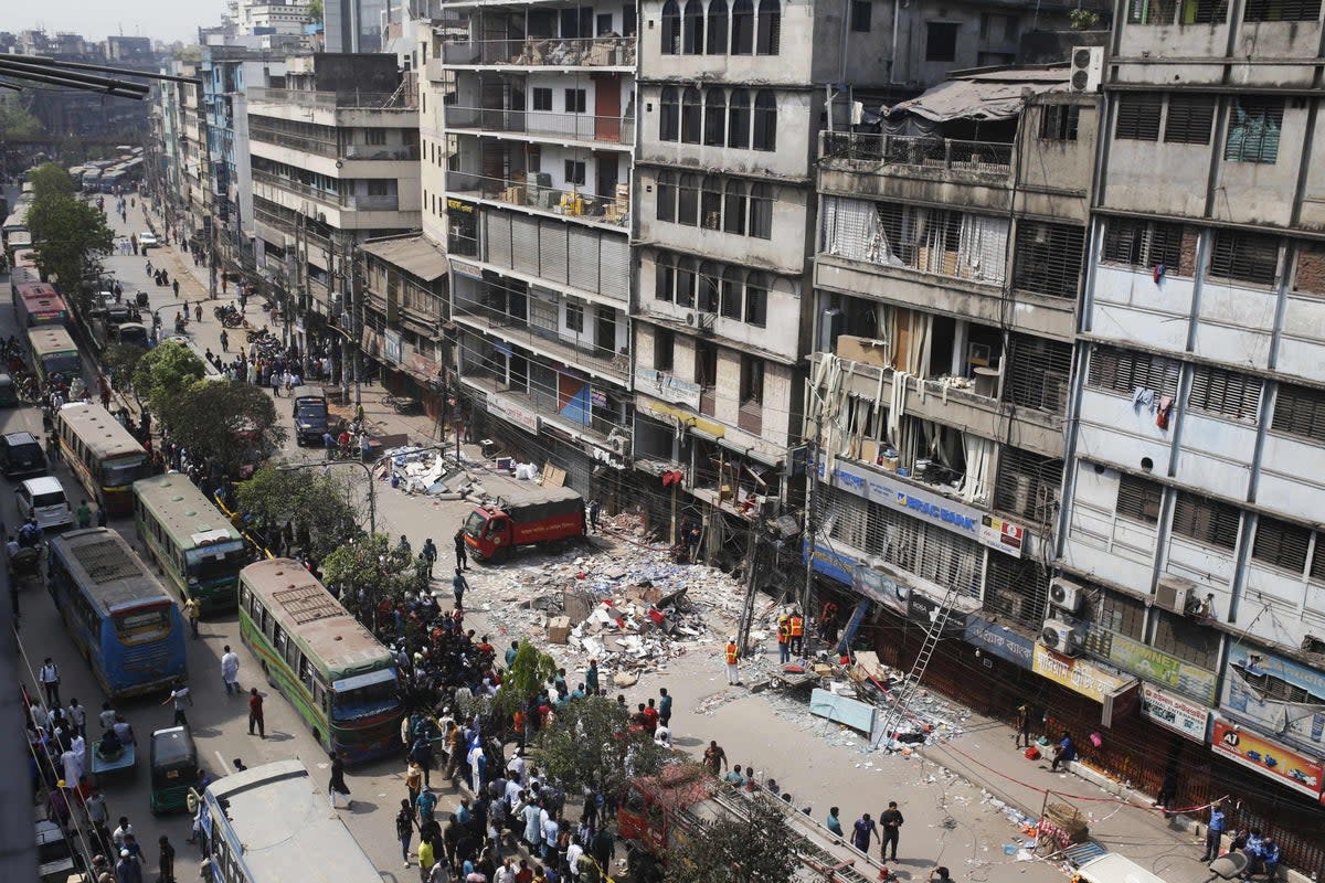 Firefighters and emergency teams work amid debris a day after an explosion inside a building in Dhaka on 8 March (AFP via Getty Images)