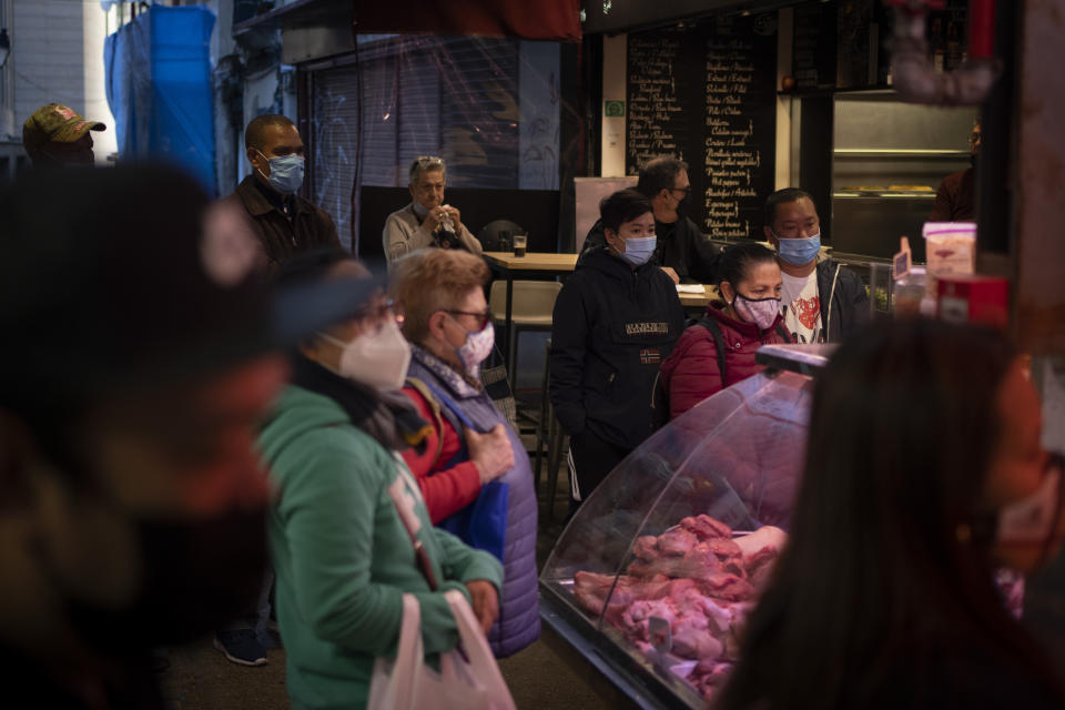 Customers wearing face masks wait to buy meat at a market in downtown Barcelona, Spain, Wednesday, May 5, 2021. (AP Photo/Emilio Morenatti)