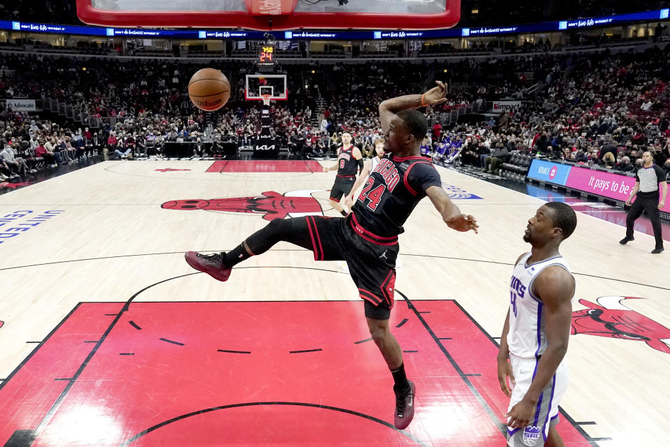 Chicago Bulls' Javonte Green (24) dunks the ball as Sacramento Kings' Harrison Barnes watches during the first half of an NBA basketball game Wednesday, Feb. 16, 2022, in Chicago. (AP Photo/Charles Rex Arbogast)