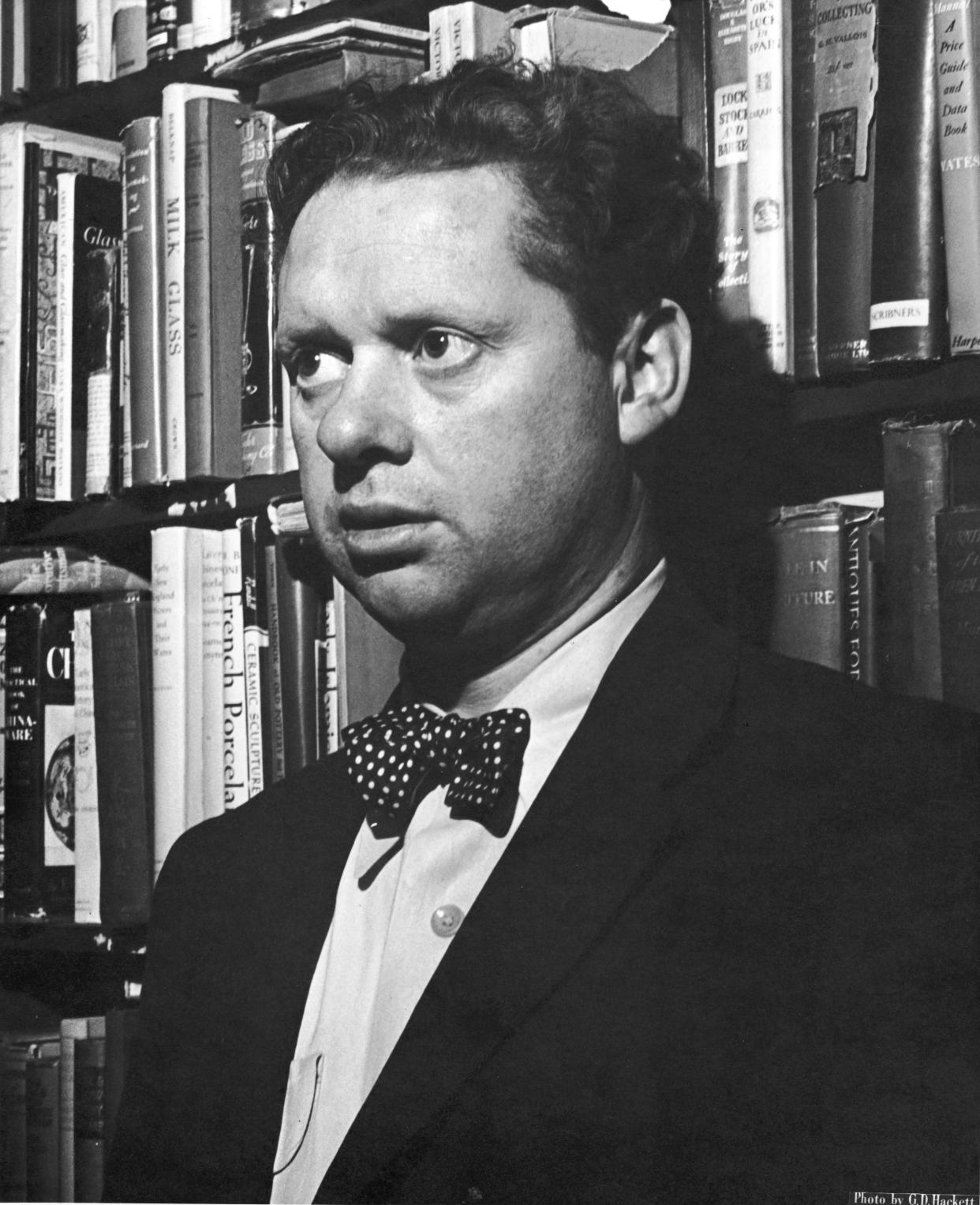 Welsh poet Dylan Thomas (1914 - 1953) stands in front of shelves of books at the Gotham Book Shop during a reception held in his honor, New York City, 1st May 1952. (Photo by G.D. Hackett/Getty Images)