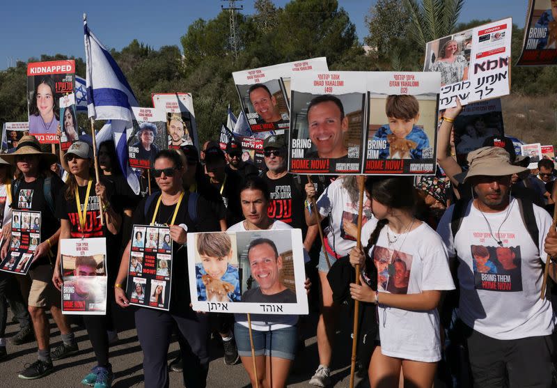 Familiares, amigos y partidarios de israelíes y de otras nacionalidades que fueron tomados como rehenes el 7 de octubre por hombres armados del grupo islamista palestino Hamás, marchan hacia Jerusalén, en una carretera entre Latrun y Jerusalén, Israel