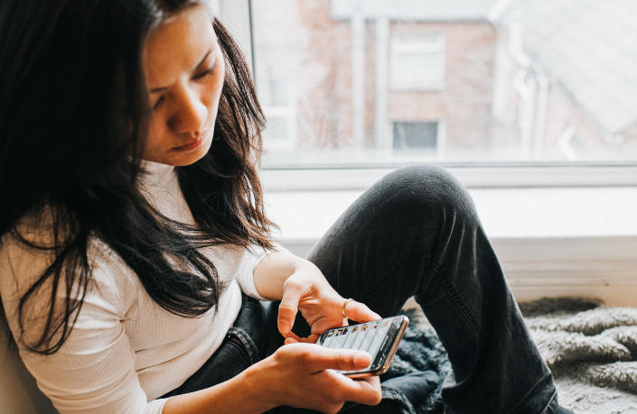 A perplexed woman checks her smart phone (Getty Images)