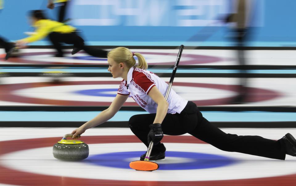 Russia's Alexandra Saitova delivers the rock to her sweepers during a round robin session against Sweden at the 2014 Winter Olympics, Sunday, Feb. 16, 2014, in Sochi, Russia. 