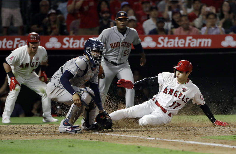 Los Angeles Angels' Shohei Ohtani (17) scores past Houston Astros catcher Robinson Chirinos on a single by Albert Pujols during the fifth inning of a baseball game Monday, July 15, 2019, in Anaheim, Calif. (AP Photo/Marcio Jose Sanchez)