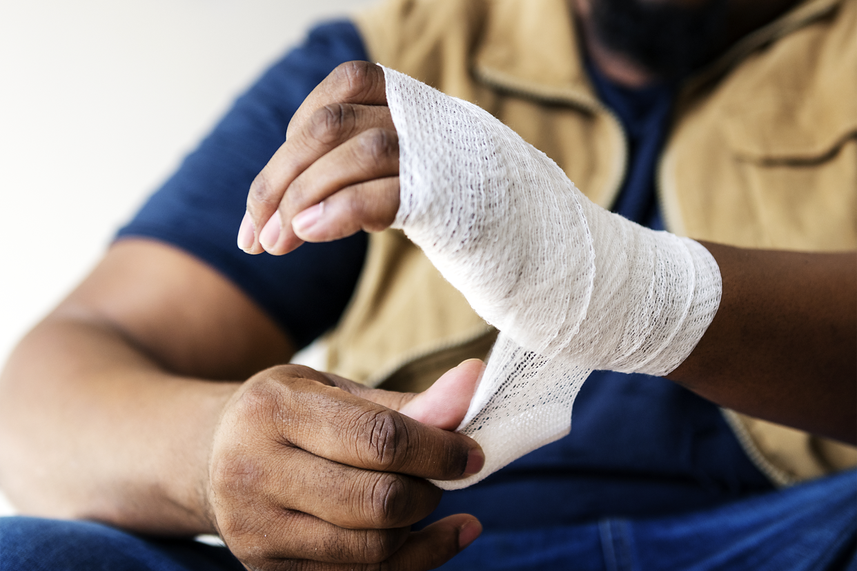 man wrapping hand in gauze