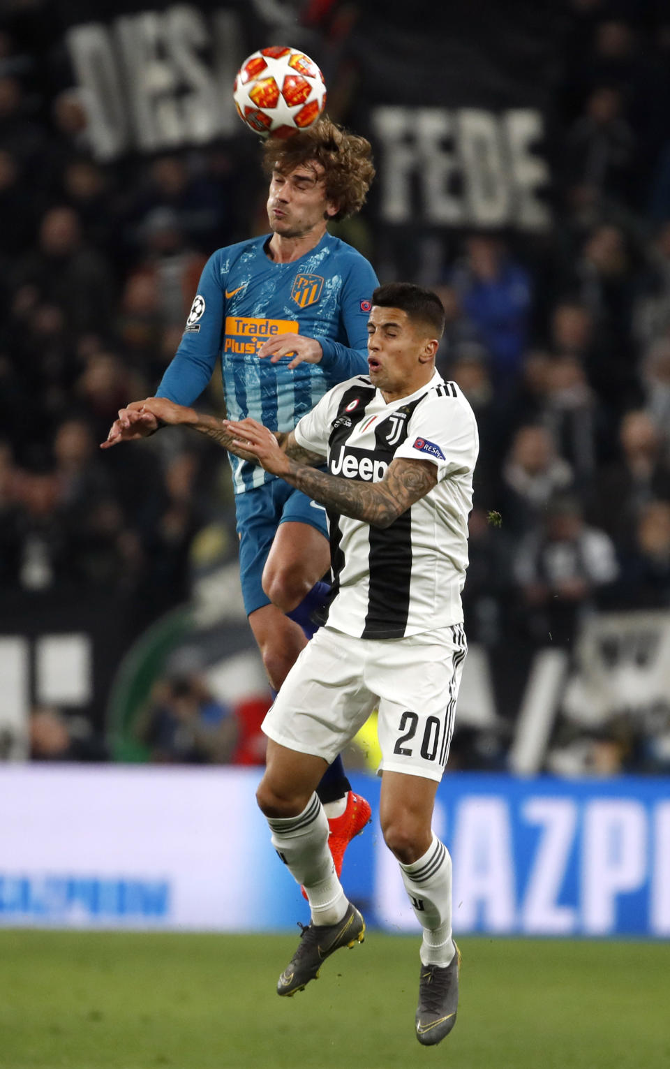 Atletico's Antoine Griezmann jumps for the ball with Juventus' Joao Cancelo, right, during the Champions League round of 16, 2nd leg, soccer match between Juventus and Atletico Madrid at the Allianz stadium in Turin, Italy, Tuesday, March 12, 2019. (AP Photo/Antonio Calanni)