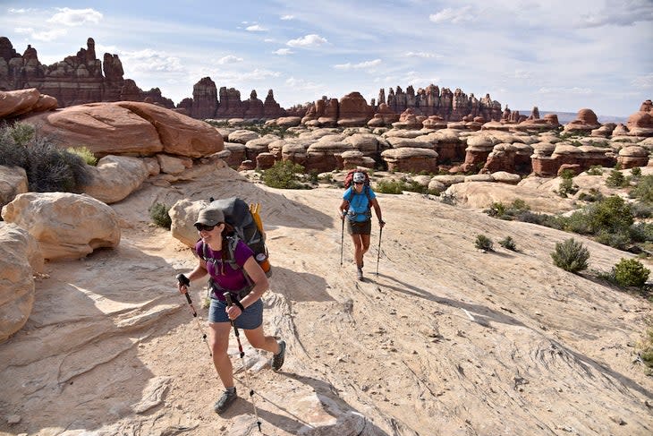 Two female backpacking on a trail through The Needles section in Canyonlands