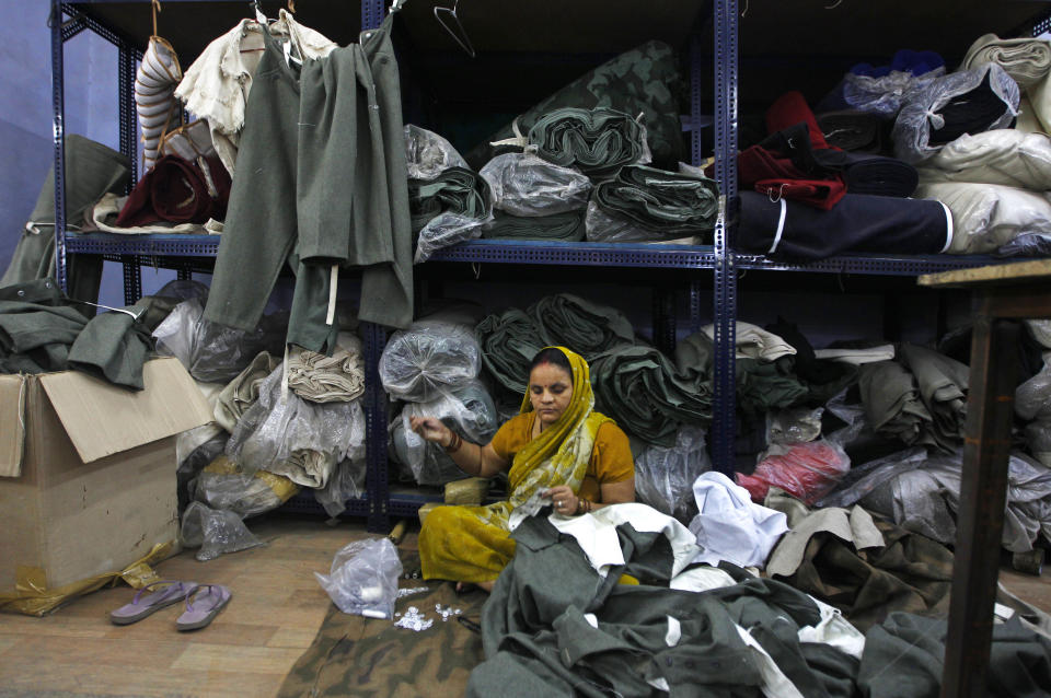 In this June 2, 2012 photograph, a worker sews dresses being prepared for a re-enactment of World war II at a workshop owned by Indian businessman Ashok Rai, unseen, in Sahibabad, India. From Hollywood war movies to Japanese Samurai films to battle re-enactments across Europe, Rai is one of the world's go-to men for historic weapons and battle attire. (AP Photo/Saurabh Das)