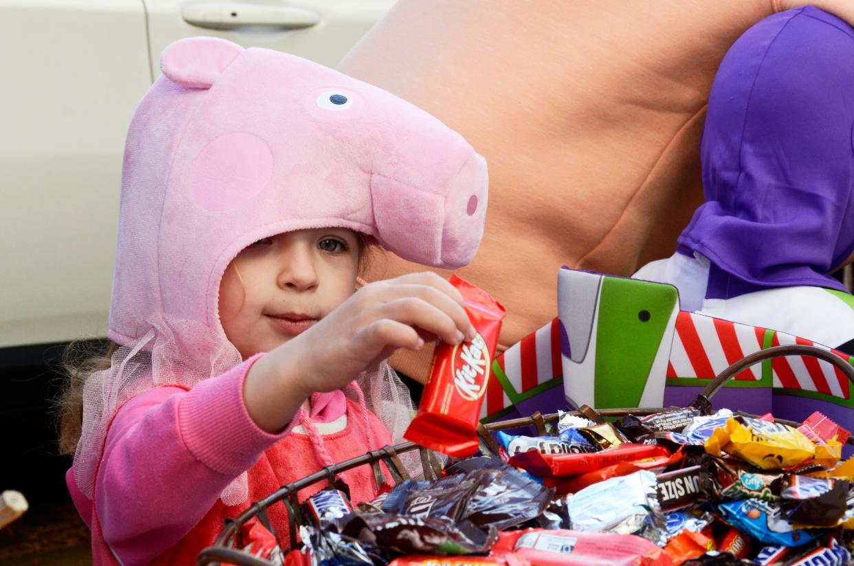 A little Peppa Pig picks out some candy during the downtown Petoskey trick-or-treating on Saturday, Oct. 29, 2022.