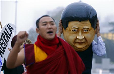 A protester wearing a giant head representing China's President Xi Jinping takes part in a demonstration calling Xi out for rights violations in Tibet in front of the European headquarters of the United Nations in Geneva October 22, 2013. REUTERS/Denis Balibouse