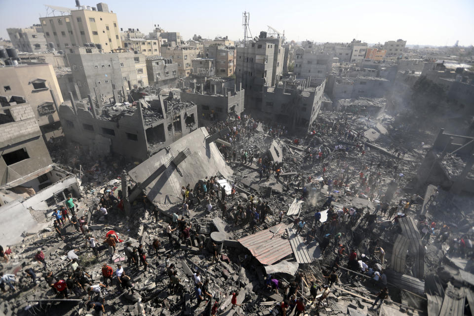 Palestinos revisan los escombros de edificios destruidos por ataques aéreos israelíes sobre la ciudad de Kan Yunis, en el sur de la Franja de Gaza, el 26 de octubre de 2023. (AP Foto/Mohammed Dahman)