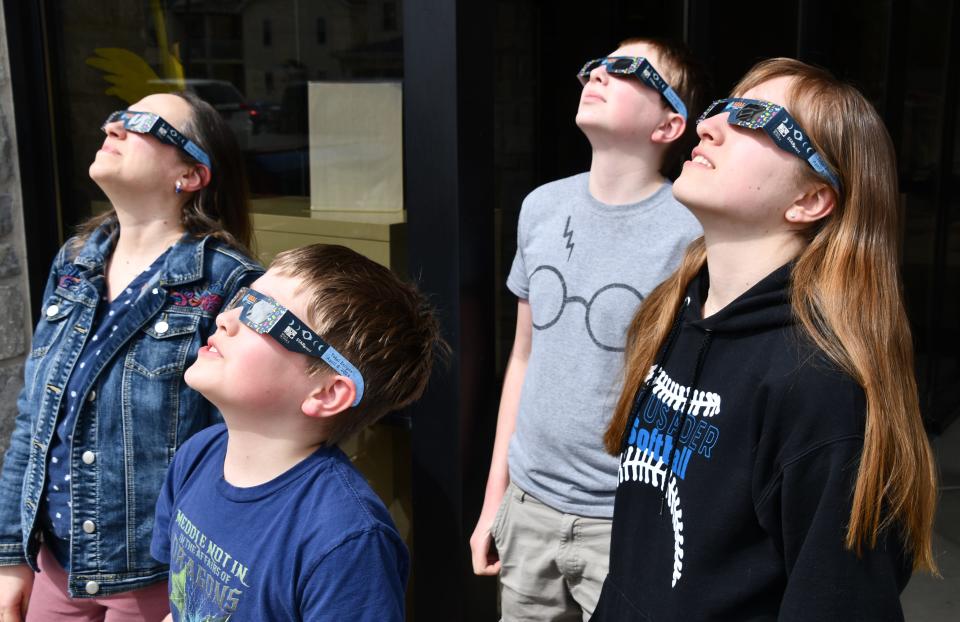 The Rhea family get a peek of the 2024 solar eclipse at the Matthews Public Library Monday afternoon.