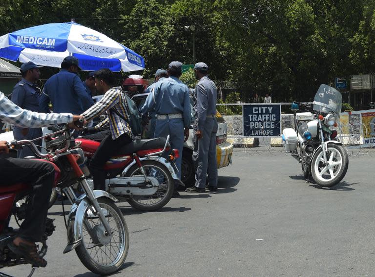 Traffic police gather at the end of a cordoned-off street leading to the hotel where the Zimbabwe and Pakistani cricket teams are staying in Lahore, northeast Pakistan on May 30, 2015