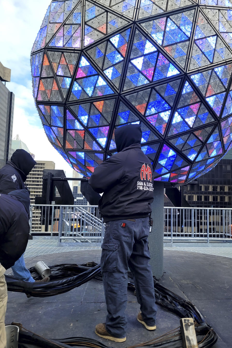 Workers test the lights on the New Year's Eve ball in Times Square on Saturday, Dec. 30, 2023 in New York. With throngs of revelers set to usher in the new year under the bright lights of Times Square, officials and organizers say they are prepared to welcome the crowds and ensure their safety. (AP Photo/Julie Walker)