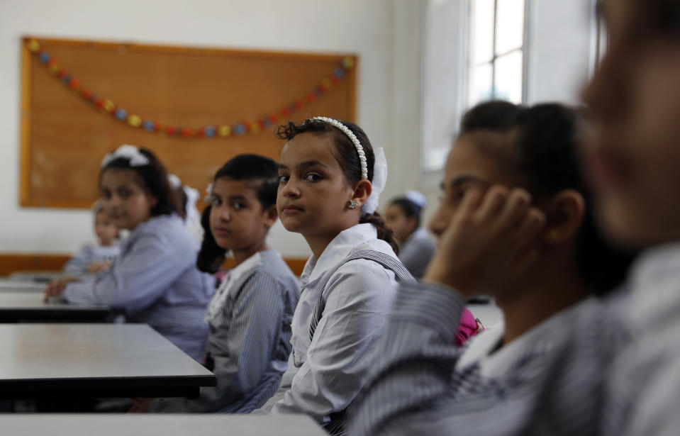 Students sit in their class on the first day of the new school year at the United-Nation run Elementary School at the Shati refugee camp in Gaza City, Saturday, Aug. 8, 2020. Schools run by both Palestinian government and the U.N. Refugee and Works Agency (UNRWA) have opened almost normally in the Gaza Strip after five months in which no cases of community transmission of the coronavirus had been recorded. (AP Photo/Adel Hana)