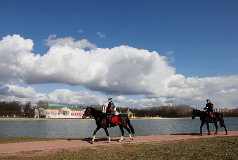 Cossacks wearing protective face masks ride horses as they patrol a territory of the Kuskovo Memorial Estate in Moscow