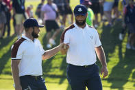 Europe's Tyrrell Hatton, left and Europe's Jon Rahm bump fists on the 3rd green during their morning Foursomes match at the Ryder Cup golf tournament at the Marco Simone Golf Club in Guidonia Montecelio, Italy, Saturday, Sept. 30, 2023. (AP Photo/Andrew Medichini)