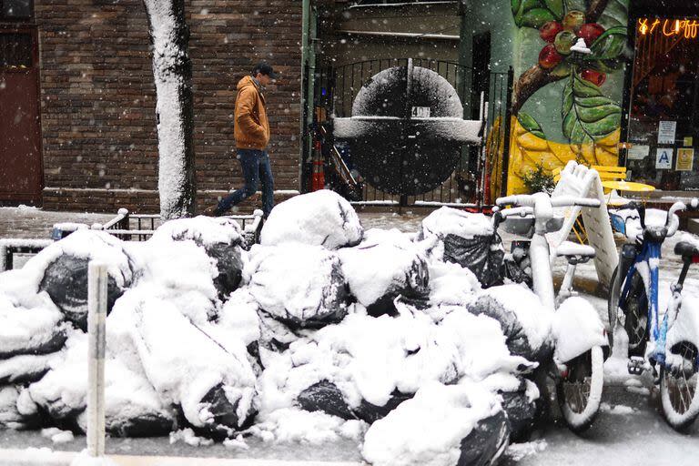 Un hombre camina por la ciudad de Nueva York en medio de una tormenta de nieve que lo cubrió todo