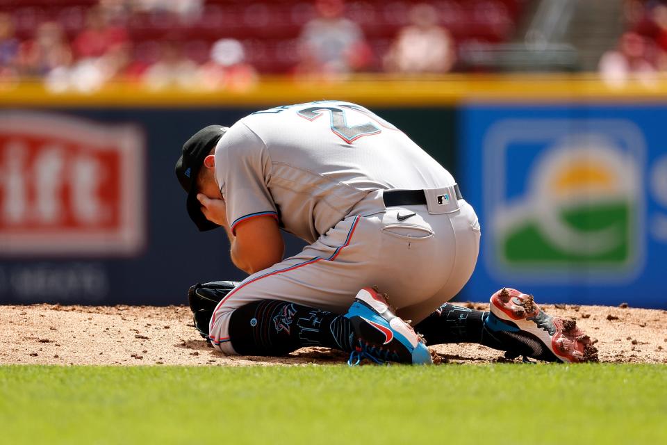 Daniel Castano grabs his face after being hit by a line drive.