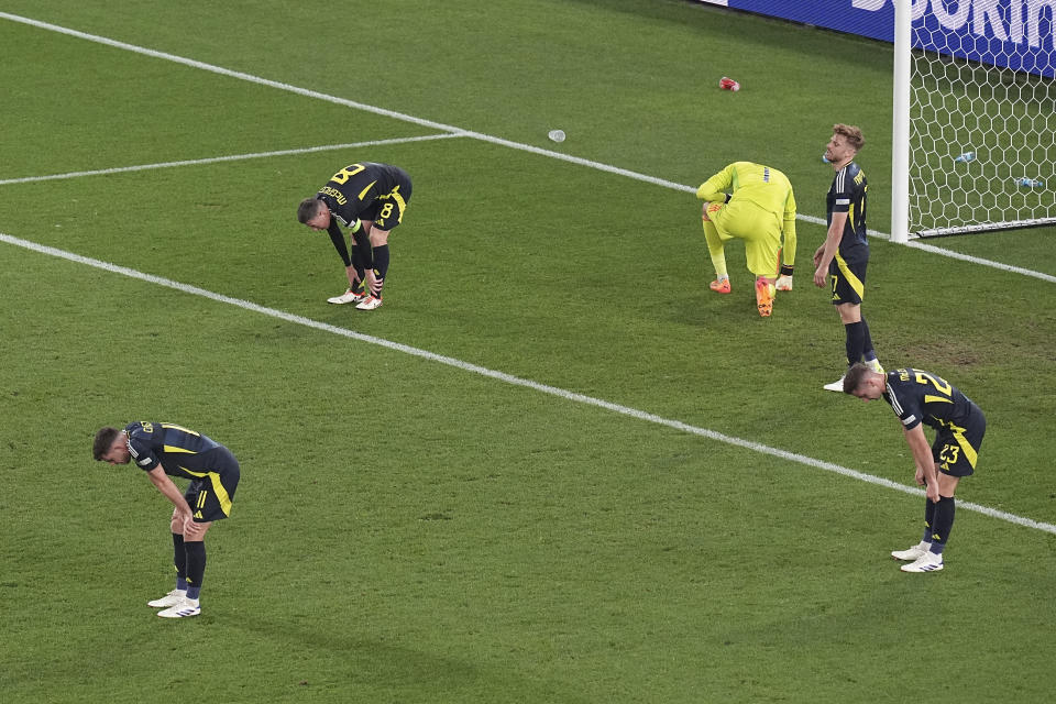 Scotland players looks down on the pitch after a Group A match between Scotland and Hungary at the Euro 2024 soccer tournament in Stuttgart, Germany, Sunday, June 23, 2024. (AP Photo/Ariel Schalit)